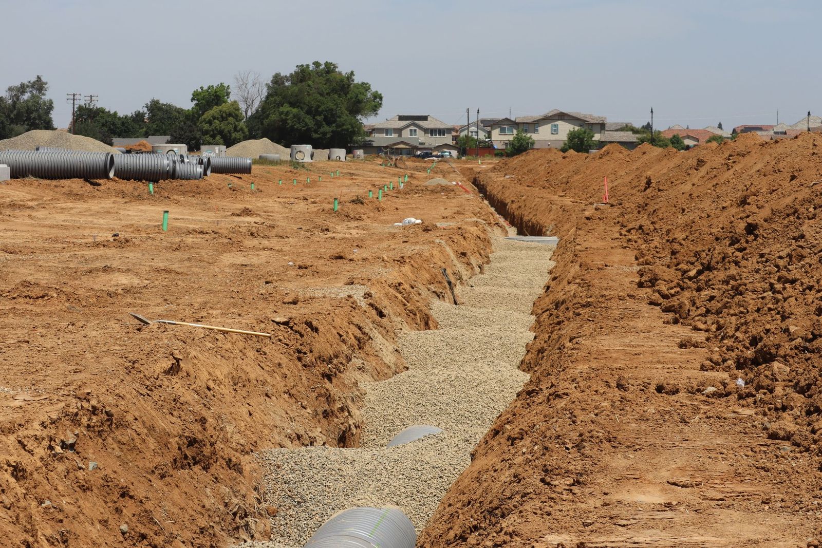Temsili görsel: uzun açık hendek; kenarda koruge borular ve beton baca elemanları